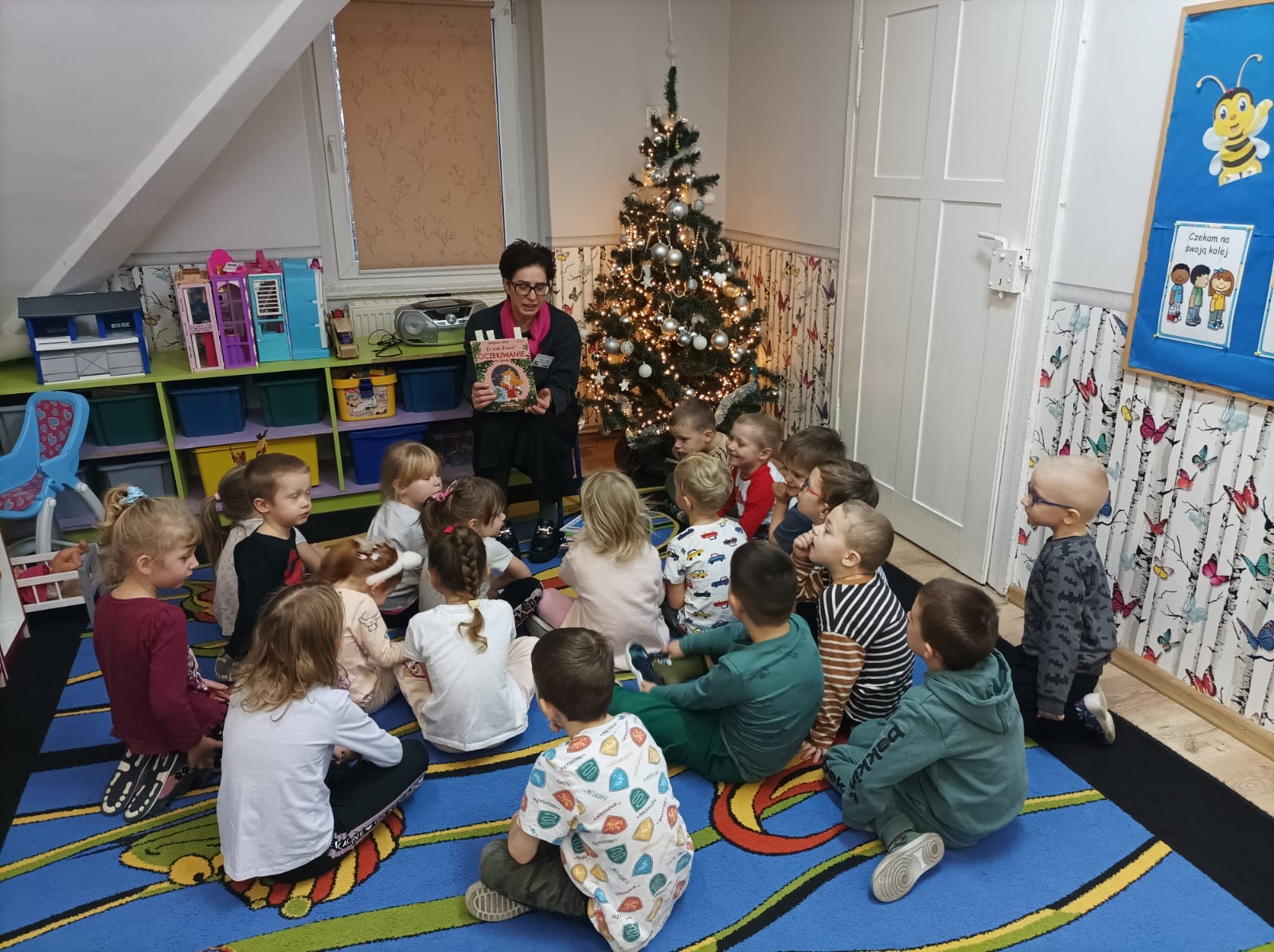 Pani pokazuje dzieciom książki i czyta